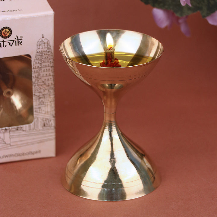 Brass Akhand Pooja Diya – A traditional, long-burning diya made of pure brass with a protective glass chimney, ideal for uninterrupted spiritual rituals and temple use. 