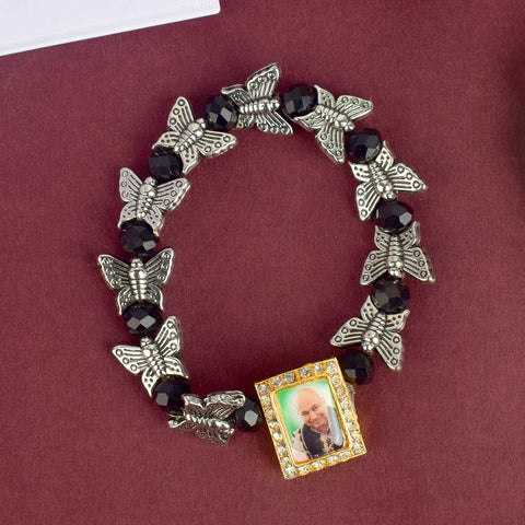Chic Guruji Swaroop Bracelet featuring black beads and silver butterfly charms, handcrafted for spiritual elegance and daily devotion. India’s Largest Pooja Accessories Brand – www.satvikworld.com