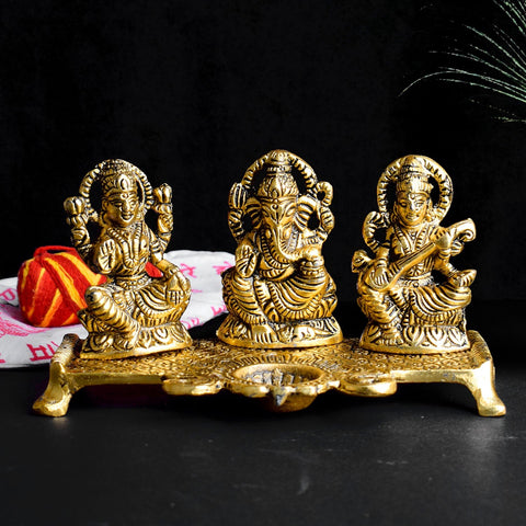 Graceful metal idol featuring Goddess Lakshmi, Goddess Saraswati, and Lord Ganesha with a diya, intricately crafted to symbolize prosperity, knowledge, and blessings. Ideal for worship or as a decorative centerpiece. India’s Largest Pooja Accessories Brand – www.satvikworld.com