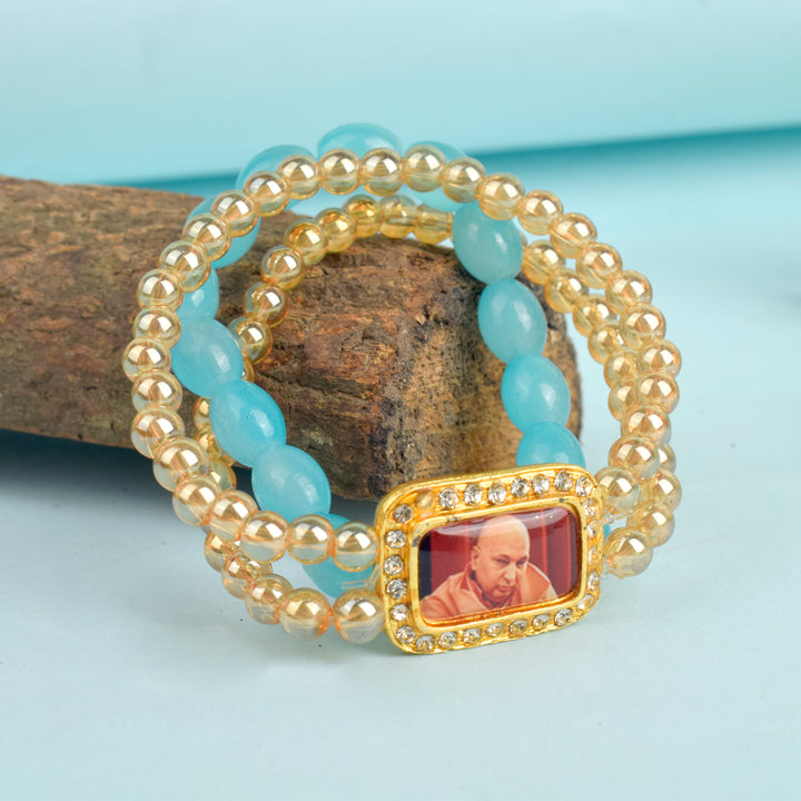 Golden Clear & Baby Blue Triple Layer Guruji Swaroop Bracelet featuring sparkling golden clear beads with a serene baby blue middle layer and Jai Guruji Swaroop – perfect for spiritual wear, meditation, and gifting. India’s Largest Pooja Accessories Brand – www.satvikworld.com