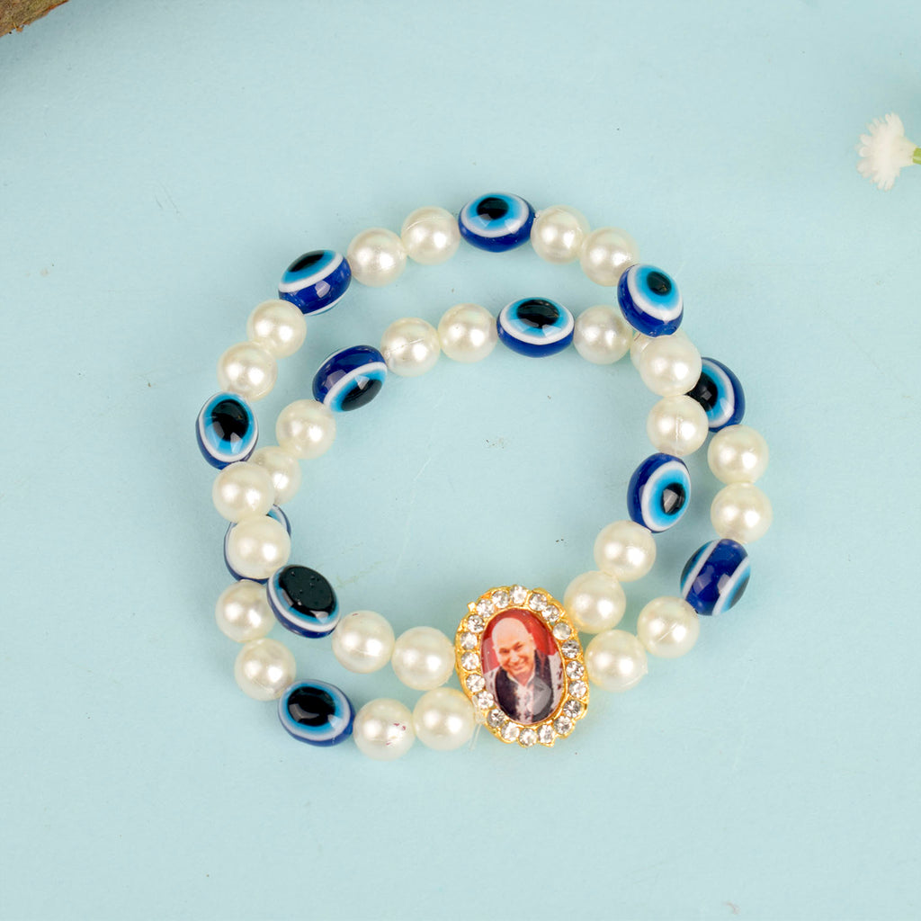 White Pearl with Evil Eye Double Layer Guruji Swaroop Bracelet featuring luminous pearls and a protective blue evil eye bead with Jai Guruji Swaroop – perfect for spiritual wear, protection, and gifting. India’s Largest Pooja Accessories Brand – www.satvikworld.com

