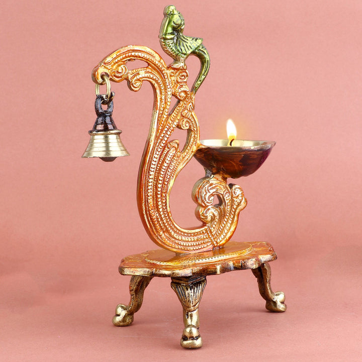 Beautiful Designer Brass Diya with Hanging Bell, featuring an exquisite design and a delicate bell that adds a charming sound, perfect for enhancing the spiritual ambiance during poojas or ceremonies. India’s Largest Pooja Accessories Brand – www.satvikworld.com