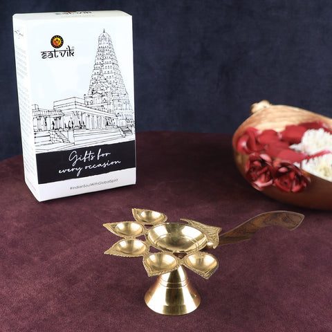 Panch Aarti Diya with Wooden Handle – A beautifully designed brass oil lamp with a sturdy wooden handle, ideal for performing aarti rituals with five wicks, creating a captivating and auspicious atmosphere. India’s Largest Pooja Accessories Brand – www.satvikworld.com